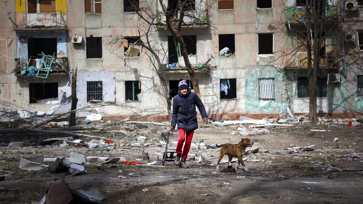 Κάτοικος της Μαριούπολης βγάζει βόλτα τον σκύλο του στα χαλάσματα της πόλης