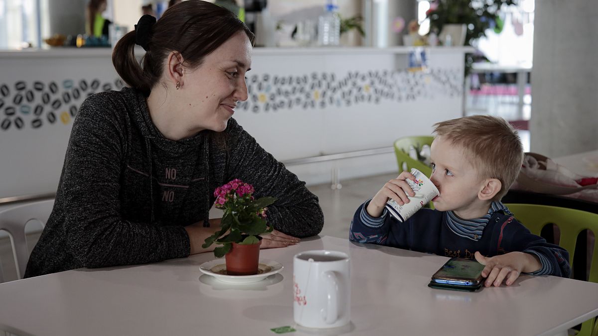 Elena Litvinova, 33, an accountant from Mykolaiv, smiles at her 3 year-old son, Artem, after an interview with AP at a refugee center in Brasov, Romania, March 30, 2022.