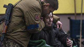 Военнослужащий успокаивает 82-летнюю Ларису Колесник, эвакуированную из Ирпеня