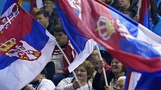 Menschen schwenken serbische Flagge