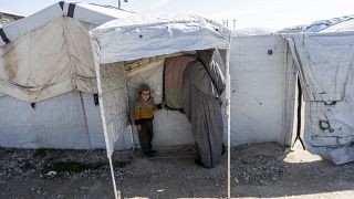 A woman and child stand in the Roj detention camp in northeast Syria.