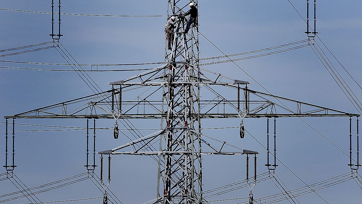 Workers prepare power supply on a high power pylon in Moers, Germany.