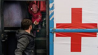 A child is helped off a bus at the registration center in Zaporizhzhia, where the International Committee of the Red Cross has a team waiting to head to Mariupol. 1/4/2022.