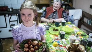Ethnic Hungarian girl Jacinta Kosza shows Easter eggs after they were painted with boiled onion-skin in her home in Ineu, Transylvania, Romania, Saturday, April 19, 2019.