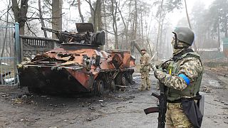 Des soldats ukrainiens examinent un véhicule militaire détruit à Irpin, près de Kyiv, en Ukraine, vendredi 1er avril 2022.