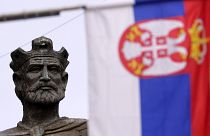 Сербский флаг на фоне памятника Лазарю Хребеляновичу в Косовска-Митровице