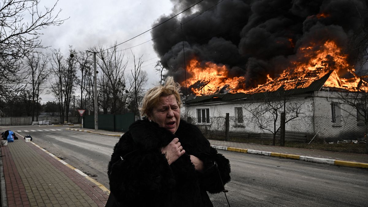 Eine Frau in Irpin vor ihrem zerstörten Haus.