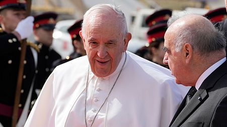 Pope Francis, left, is received by Malta's President George Vella upon his arrival at Malta International airport in Luqa, Saturday, April 2, 2022