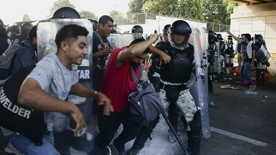 Members of the National Guard clash with migrants taking part in a caravan heading to Mexico City.