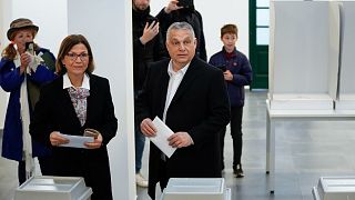 Hungary's nationalist prime minister, Viktor Orban, center, and his wife Aniko Levai, left, cast their vote for general election in Budapest, Hungary, Sunday, April 3, 2022. 