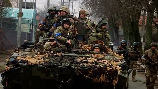 Ukrainian troops clear roads in a city north of Kyiv