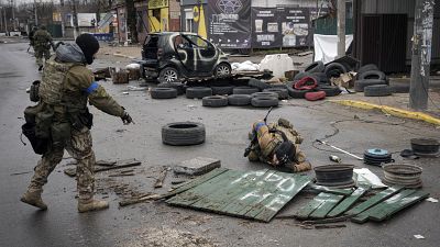 جنود أوكرانيون يتفقدون الشوارع بحثًا عن أجسام مفخخة في ضاحية كييف.