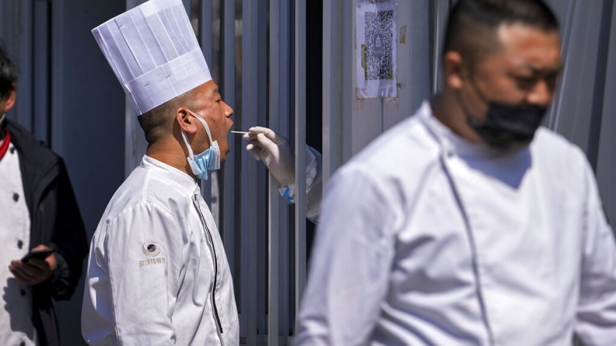 A restaurant chef gets their throat swab taken at a coronavirus testing site