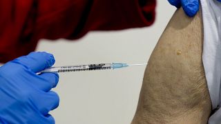 رجل يحصل على جرعة معززة من اللقاح في مركز التطعيم في فرانكفورت، ألمانيا