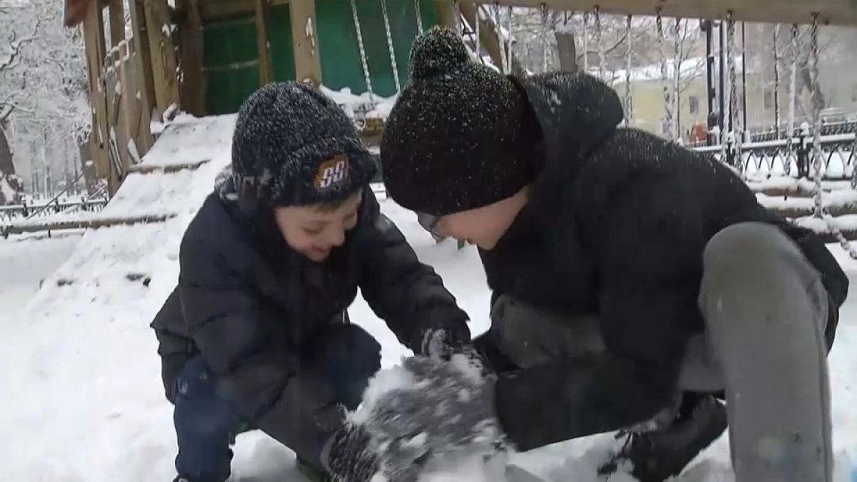 Duas crianças brincam na neve em Moscovo, Rússia