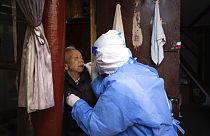 عامل طبي يجري اختبار الكشف عن عن كوفيد لمسنة في شنغهاي، الصين