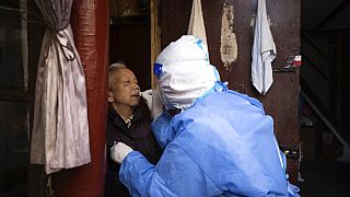 A medical worker conducts antigen testing for an elder resident in Shanghai, China, on Sunday, April 3, 2022.