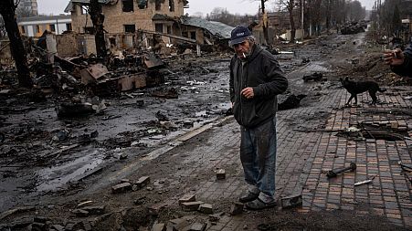 Konstyantyn, 70, smokes a cigarette amid destroyed Russian tanks in Bucha, in the outskirts of Kyiv, Ukraine, Sunday, April 3, 2022.