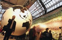 In this file photo, a man speaks on his cell phone in front of a giant globe in Copenhagen