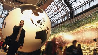 In this file photo, a man speaks on his cell phone in front of a giant globe in Copenhagen