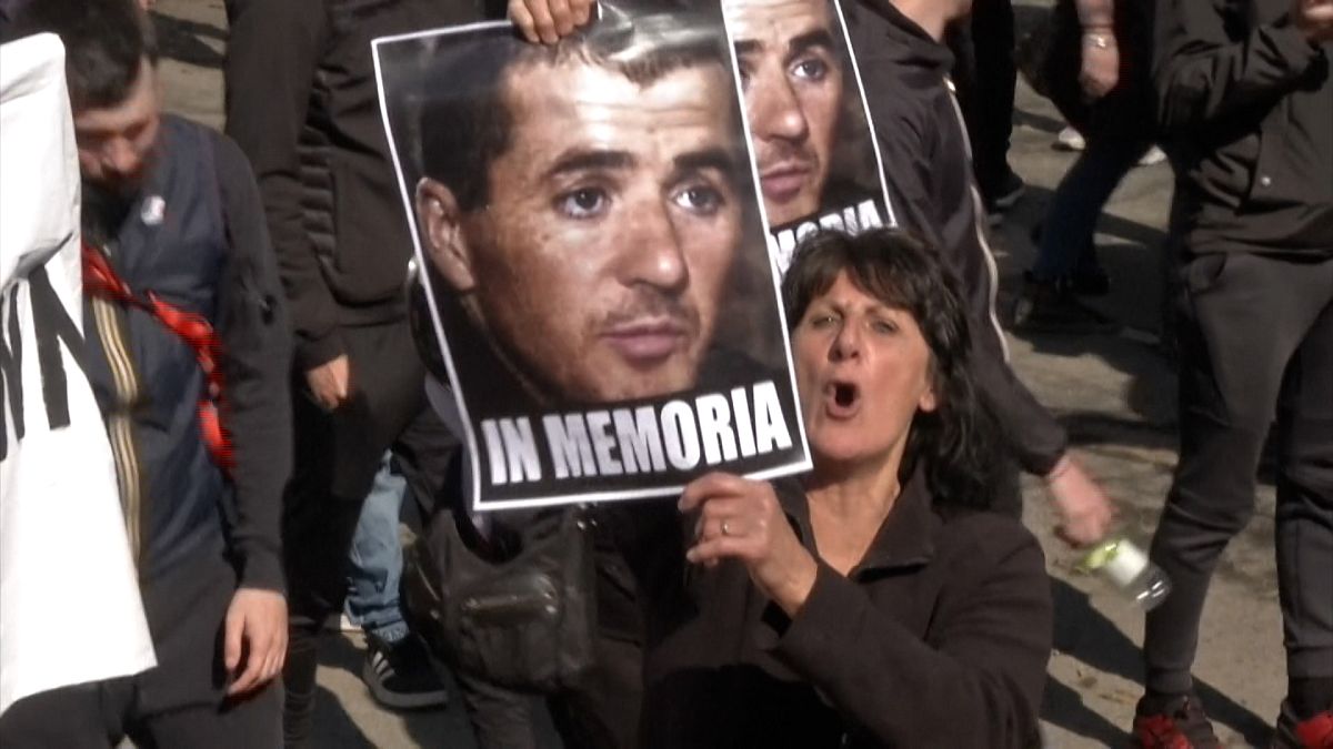 Woman holds Yvan Colonna's portrait in Ajaccio, Corsica