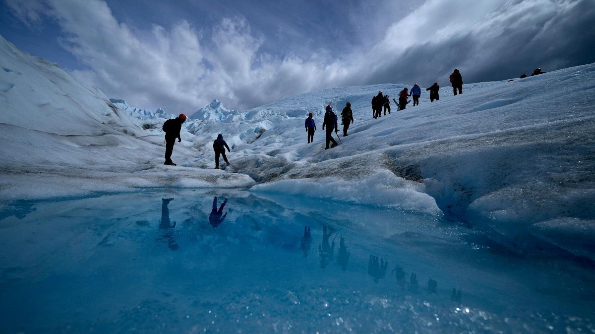 Tourists walk on the Perito Moreno Glacier at Los Glaciares National Park, near El Calafate, Argentina, Nov. 2, 2021.