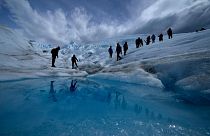 Tourists walk on the Perito Moreno Glacier at Los Glaciares National Park, near El Calafate, Argentina, Nov. 2, 2021.