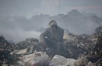 A man smokes a cigarette at at Dandora, the largest rubbish dump in Nairobi, Kenya.