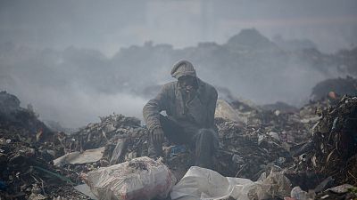 A man smokes a cigarette at at Dandora, the largest rubbish dump in Nairobi, Kenya.