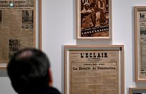 زائر يشاهد جرائد حول أعمال الشغب المناهضة لليهود في قسنطينة عام 1934 خلال معرض "اليهود والمسلمون من فرنسا الاستعمارية إلى الوقت الحاضر"، في متحف تاريخ الهجرة بباريس