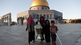 أطفال يتصورون إلى جانب فانوس رمضان مقابل المسجد الأقصى في القدس