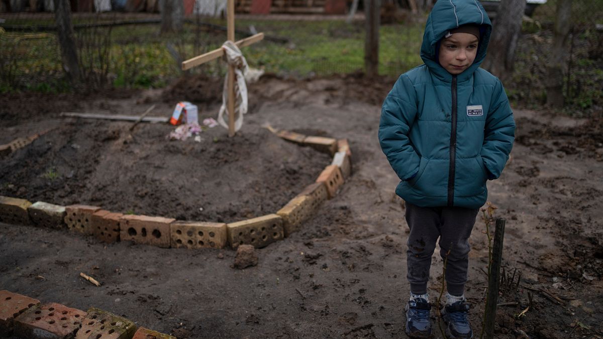Vlad Tanyuk, 6 anos, junto à sepultura improvisada da mãe, nos arredores de Kiev