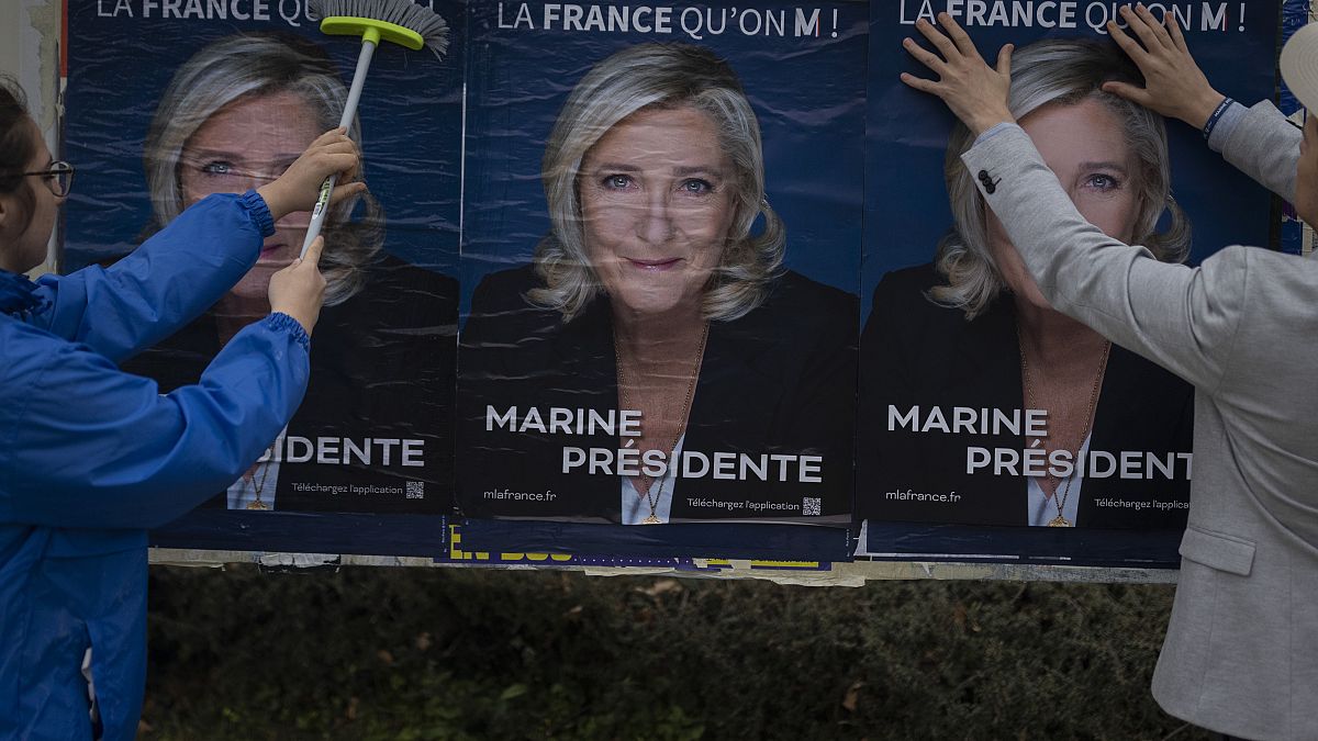 Sympathisanten kleben Wahlplakate der rechtsextremen Präsidentschaftskandidatin Marine Le Pen in Vigneux-De-Bretagne, Westfrankreich (29. März 2022)