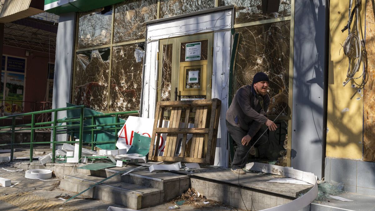 Um homem sai de uma farmácia atingida por um bombardeamento russo, em Mykolaiv, Ucrânia