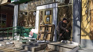 Un homme sort d'une pharmacie endommagée après un bombardement qui a tué neuf civils la veille, à Mykolaïv en Ukraine, mardi 5 avril 2022.