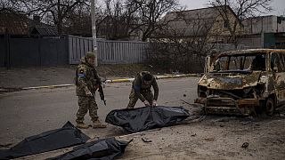 Des soldats ukrainiens récupèrent les restes de quatre civils tués à l'intérieur d'un véhicule calciné à Bucha, en Ukraine, mardi 5 avril 2022.