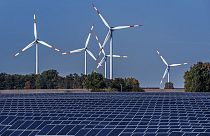 Des éoliennes tournent derrière un parc solaire à Rapshagen, en Allemagne, le 28 octobre 2021.