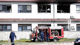 Firefighters stand in front of burnt hospital rooms after the fire.