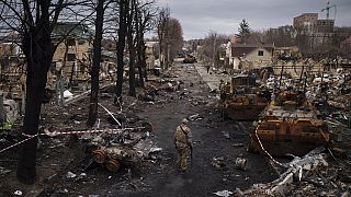 Ein ukrainischer Soldat inmitten zerstörter russischer Panzer im Kiewer Vorort Butcha (6. April 2022)