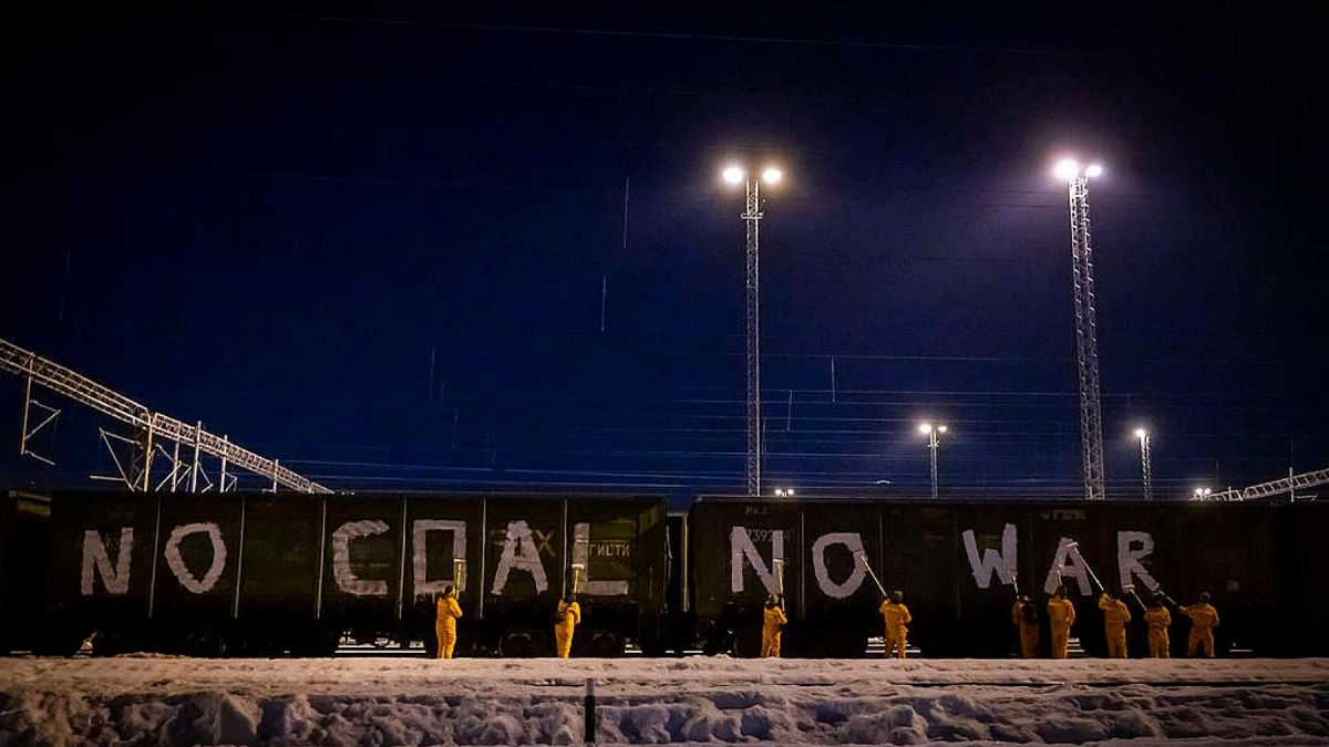Activists daub 'No coal no war' slogan on the side of freight train carriages in Kouvola, Finland