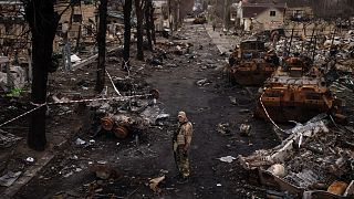 A Ukrainian serviceman stands amid destroyed Russian tanks in Bucha, on the outskirts of Kyiv, Ukraine, Wednesday, April 6, 2022.