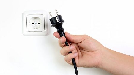 A plug is pulled out of a socket.