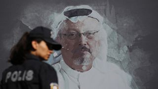 A Turkish police officer walks past a picture of slain Saudi journalist Jamal Khashoggi in Istanbul in 2019