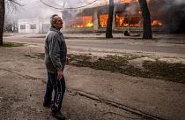 Un civil devant un bâtiment incendié à Severodonetsk en Urkaine