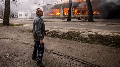 Un civil devant un bâtiment incendié à Severodonetsk en Urkaine