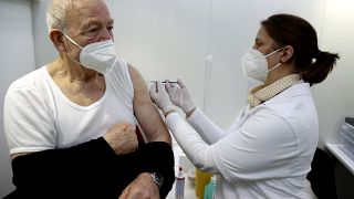 An elderly man gets an injection of the AstraZeneca COVID-19 vaccine at the vaccine center in Ebersberg near Munich, Germany, Monday, March 22, 2021.