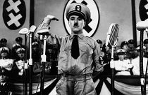 Charlie Chaplin, whose parents were both half-Romani, caricatures Adolf Hitler in The Great Dictator (1940)