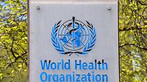Az Egészségügyi Világszervezet logója a genfi központ előtt