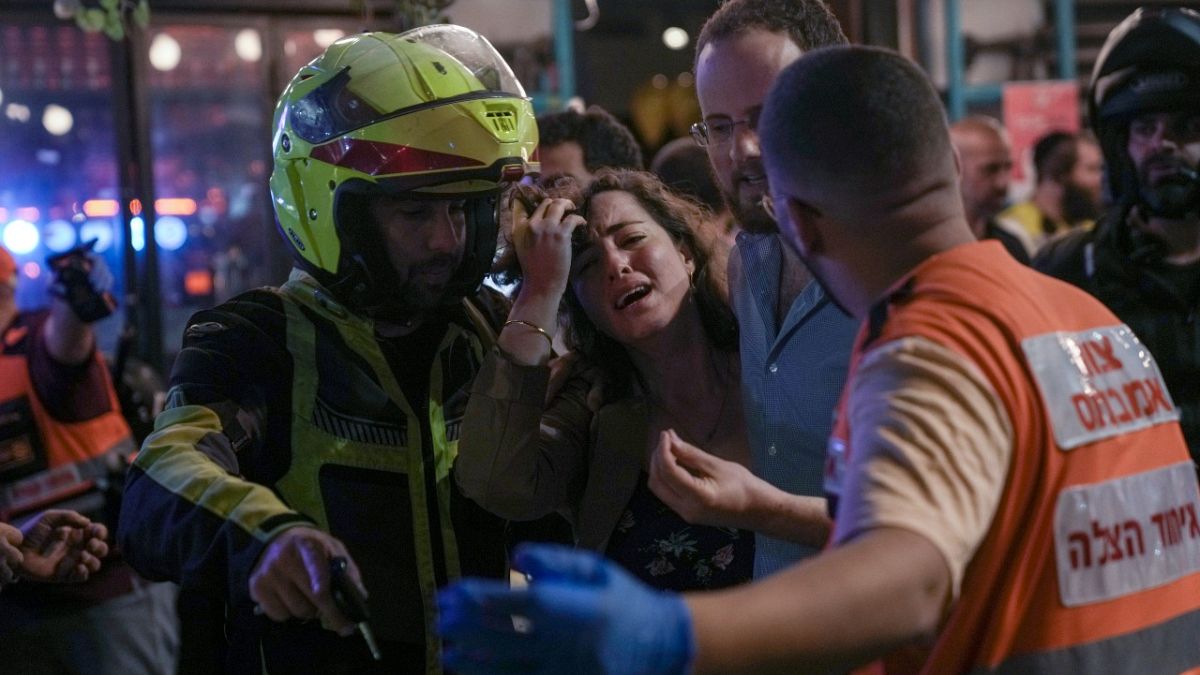 A woman reacts at the scene of a shooting attack In Tel Aviv, Israel, Thursday, April 7, 2022. Israeli health officials say two people were killed and at least 10 others hurt.