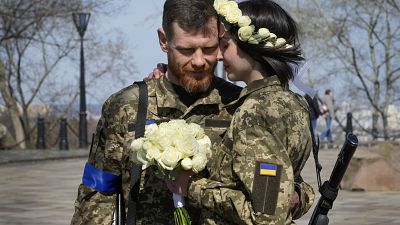 أناستاسيا وفياتشيسلاف يتعانقان قبل حفل زفافهما في حديقة مدينة في كييف - أوكرانيا، الخميس، 7 أبريل 2022